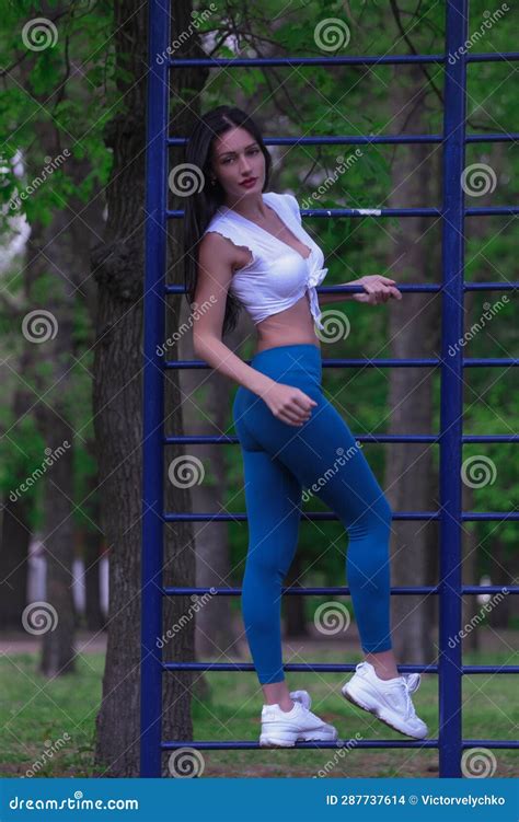 A Beautiful Slender Brunette Girl Athlete Coach Is Engaged On The Street Platform Stadium In