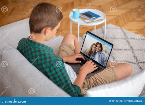 Adolescent Garçon Assis Sur Un Canapé Avec Ordinateur Portable