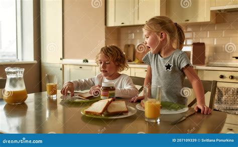Irmãozinho E Irmã Tomando Café Da Manhã Sozinhos De Manhã Em Casa Adorável Garoto Fazendo Um