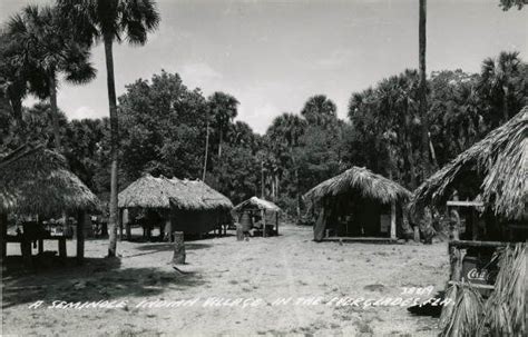 An Old Black And White Photo Of Some Huts In The Middle Of Palm Tree