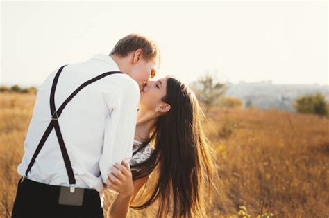 liebespaar in weiß gekleidet küssen im freien berühren sanft kostenlose foto