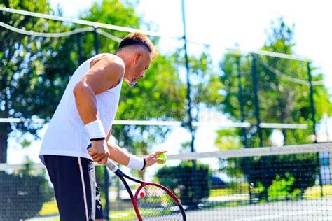 Senior Caucasian Man Playing Tennis On Court Holding Tennis Racket Day