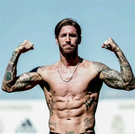 A Man With Tattoos On His Arms And Chest Flexing Its Muscles In Front