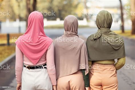 Rearview Of Three Muslim Ladies Wearing Hijabs Walking Together Outside