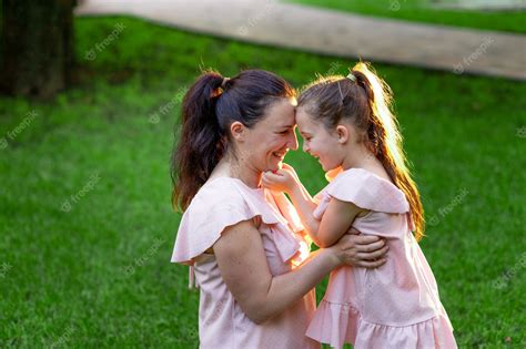 Premium Photo Mother And Daughter 5 6 Years Old Sit In The Park On The Grass In The Summer And