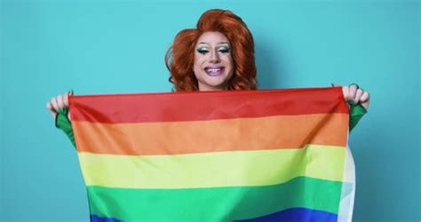 Happy Drag Queen Holding Rainbow Flag While Dancing Inside The Studio
