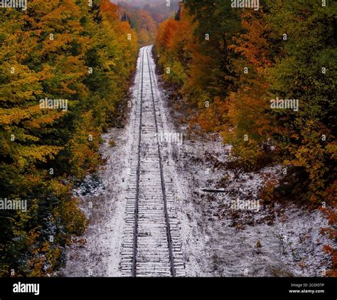 Autumn Colors And Fresh Snowfall Along Railroad Tracks In Michigans