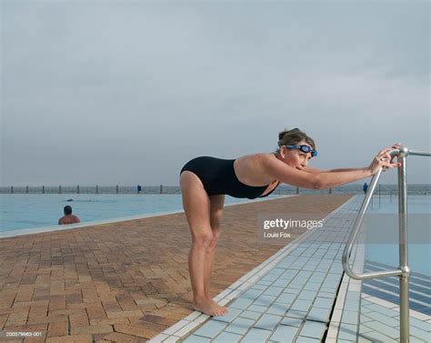 Mature Woman In Swimsuit Stretching By Swimming Pool Photo Getty Images