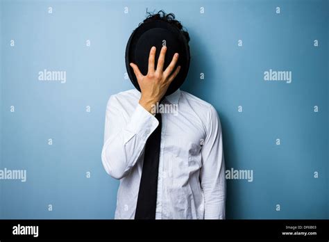 Young Man Hiding His Face Behind His Bowler Hat Stock Photo Alamy
