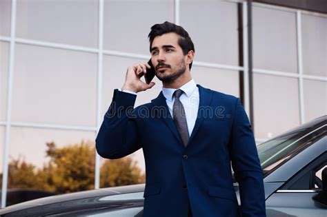 Attractive Young Man Talking On Phone Near Car Outdoors Stock Photo