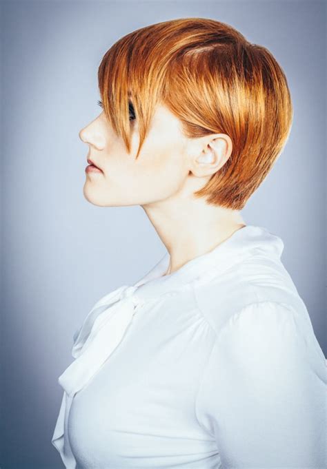 Subtly longer crown, exposed ears and a short length that tapers down the neck, with light to no sideburns. Short dark blonde hair pushed behind the ear