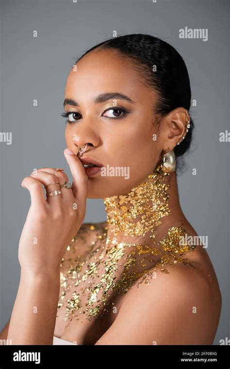 African American Woman With Golden Piercing And Foil On Chest Touching