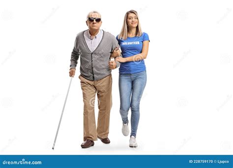 Full Length Portrait Of A Young Female Volunteer Helping An Elderly