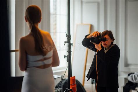 Woman Professional Photographer Working In The Studio With A Model