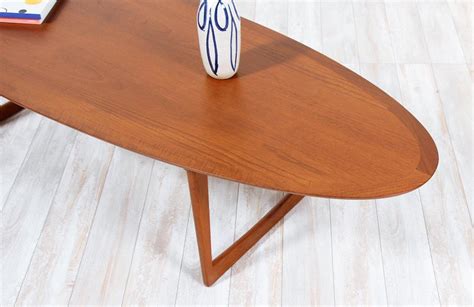 The shape of the tabletop is reminiscent of a surfboard, and the empty space between the top and the frame gives the tabletop an airy, hovering appearance. Danish Modern Teak Surfboard Style Coffee Table by Moreddi ...