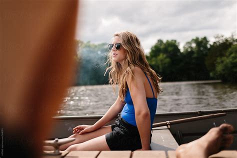 Sitting On A Dock A Girl Enjoys A Moment Of Relaxation By Stocksy Contributor Howl Stocksy
