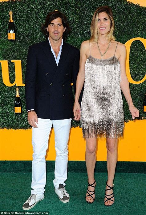 Two People Standing Next To Each Other On A Green Carpet