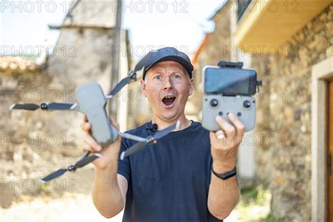 Excited Man Holding His New Drone With Remote And Phone Ready To Fly