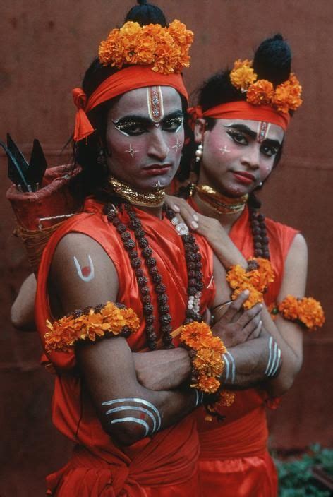Two People Dressed In Orange And White Are Posing For The Camera
