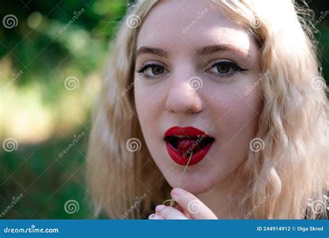 Retrato De Una Adolescente Rubia Encantadora Con Dientes Que Se Cepillan Mordiendo Una Cereza
