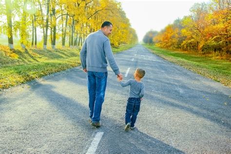 Un Padre Feliz Con Su Hijo Está Caminando Por La Carretera En El Parque