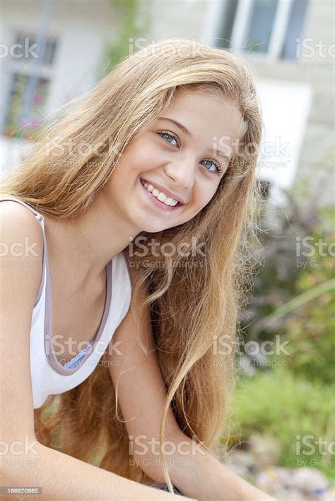 Portrait Of Smiling Blond Teenage Girl Posing Outdoors