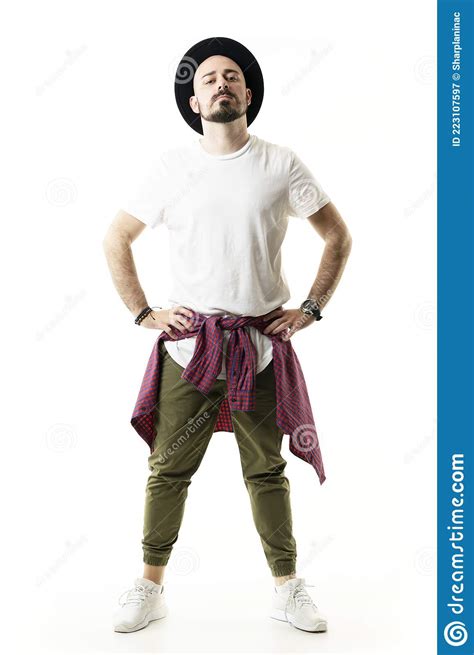 Confident Cocky Attitude Hipster With Hat In Chino Pants Posing With Hands On Hips Stock Image