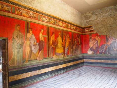 A Room With Paintings On The Wall And Tiled Floor