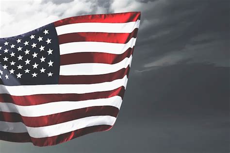 Premium Photo American Flag Waving In The Air With A Dramatic Sky