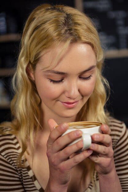 premium photo blonde woman drinking a cup of coffee