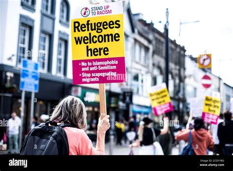 A Photograph Sign Stating Refugees Welcome Here Held By A Woman Marching In Solidarity In