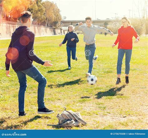 Company Of Teenagers Playing Football In Park Stock Photo Image Of