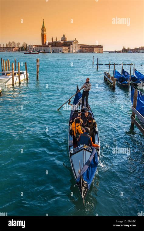 Gondolas And Gondoliers With San Giorgio Maggiore Island In The