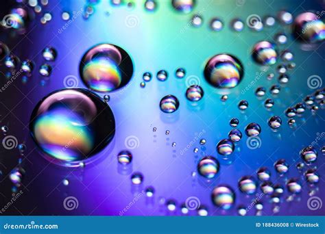 Water Droplets On Iridescent Background With Rainbow Colors Stock Photo