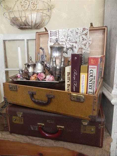 Two Suitcases Stacked On Top Of Each Other With Tea Pots And Books In Them