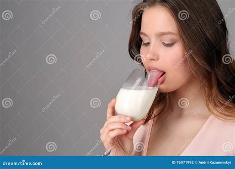 Girl Licking Milk From A Wine Glass Close Up Gray Background Stock Photography CartoonDealer