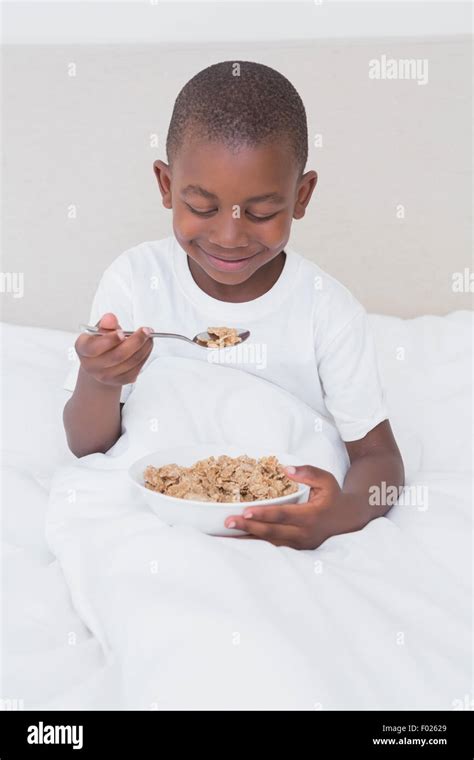 Pretty Little Boy Eating Cereals In Bed Stock Photo Alamy