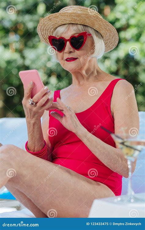 Blonde Haired Mature Woman Wearing Red Swimming Suit Sunbathing Stock