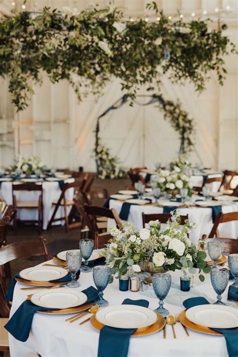 The Tables Are Set With Blue And White Linens Silverware And Greenery