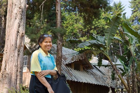 Cheerful Smiling Mature Thai Woman Is Standing Near Farm House In