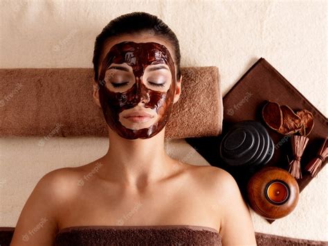 Free Photo Young Woman Relaxing With Facial Mask On Face At Beauty Salon Indoors