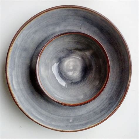 A Gray And Brown Bowl Sitting On Top Of A White Table