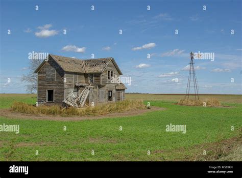 Abandoned Farm House In Field With Broken Windmill Stock Photo Alamy