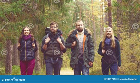 Young Happy Friends Walking In Forest And Enjoying A Good Autumn Stock