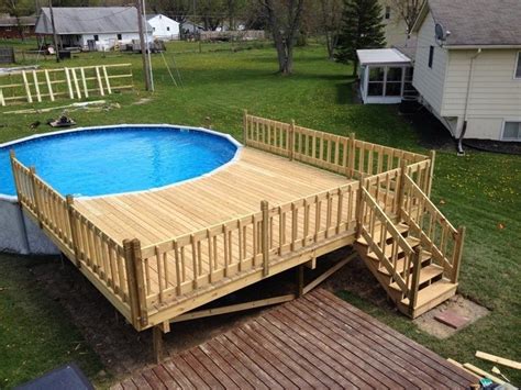 Run the deck boards under the top rails How to Build an Above Ground Pool Deck | Decks.com