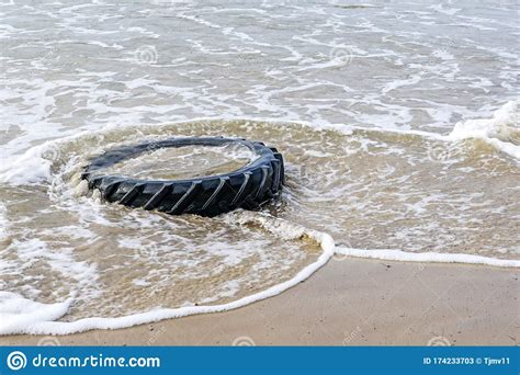Marine Pollution By Industrial Waste Tractor Tire In Sea Water Stock