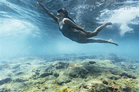 Woman In Swimsuit And Diving Goggles Playing With Waves Underwater