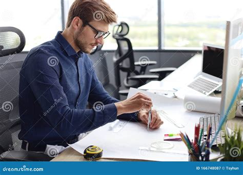 Shot Of A Handsome Male Architect Working On A Design In His Office