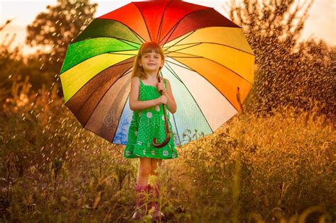 Happy Child Girl Walk With Multicolored Umbrella Under Rain Stock Image