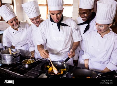 Group of chefs preparing food in kitchen Stock Photo - Alamy